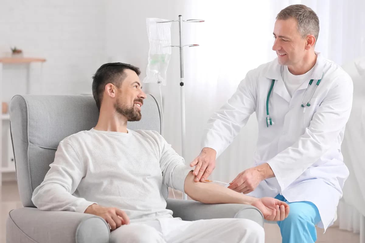 A medical professional administering in-home IV vitamin therapy for a patient